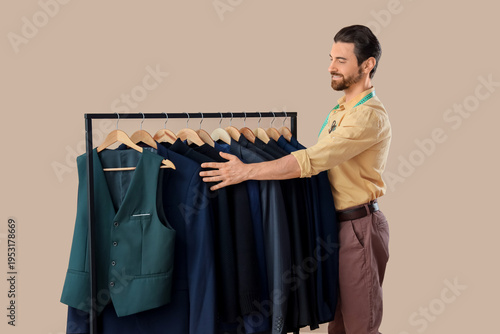 Male tailor and rack with j...