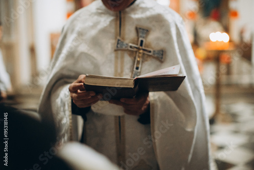 Priest holding holy book during christian church service