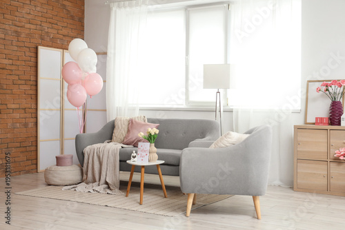 Interior of living room decorated for Mother's Day with sofa, armchair and balloons