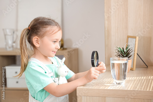 Cute little girl magnifying...
