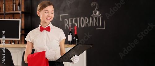 Young waitress with menu in...