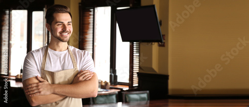 Young male waiter in restau...