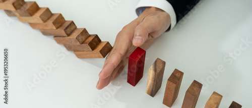 insurance with hands protect domino. Businessman hands stop dominoes falling in business crisis. business risk control and planning and strategies to run prevent insurance businesses.