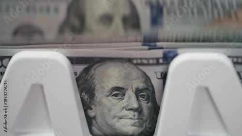 Close-up view of high denomination $100 bills in counting machine. Banking and business concept.
