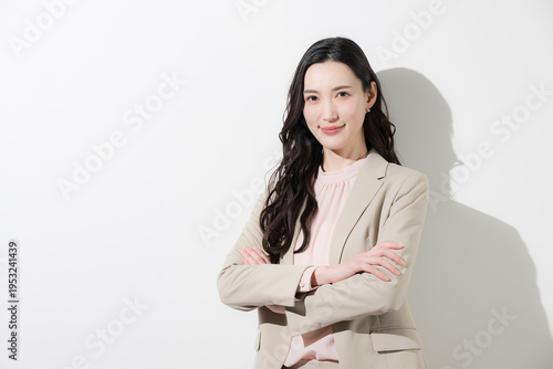 かわいいスーツの日本人女性のカメラ目線の笑顔　多幸感や成功や自信あふれる春色ビジネスイメージ