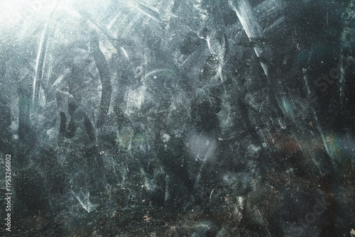 The glass surface texture is dirty with fingerprints and dust spots under bright light.