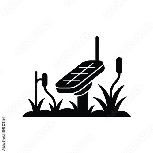 A black silhouette of a solar panel with surrounding reeds and grass