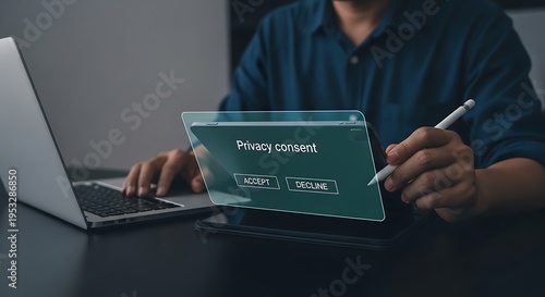 Man considering privacy consent options on a tablet while working at his laptop