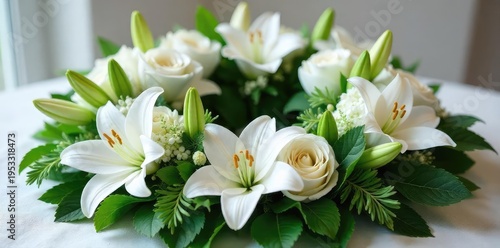 A classic, elegant funeral wreath crafted with white lilies and lush green foliage  Perfect for a somber and respectful memorial service  Shows exquisite detail and craftsmanship , grief, sympathy