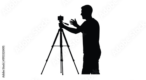 Silhouette of a man recording video content using a mobile phone mounted on a portable tripod stand