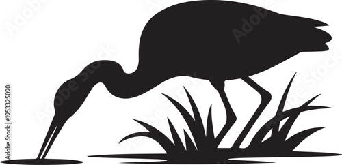 Black silhouette of bird bending to touch water with grass