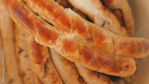 Extreme close-up of freshly grilled sausages. The golden brown skin has distinct char marks, highlighting the juicy, savory texture. Perfect for food festivals, barbecues, and street food menus