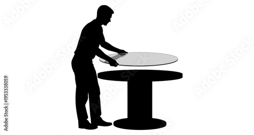 Silhouette of man placing round glass tabletop onto pedestal table base isolated on white