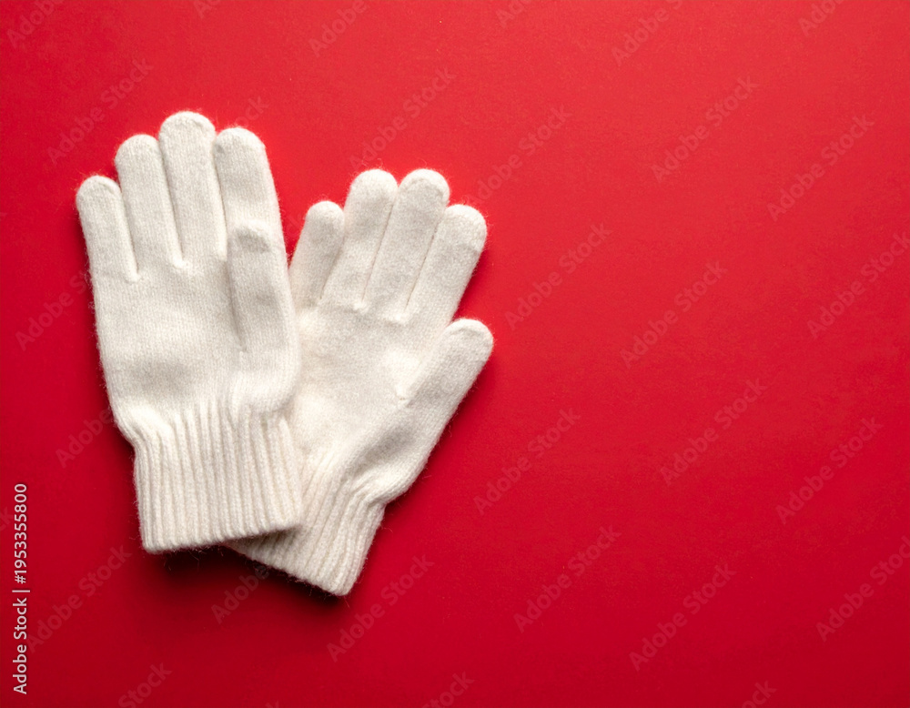 Obraz premium White knit gloves on red background