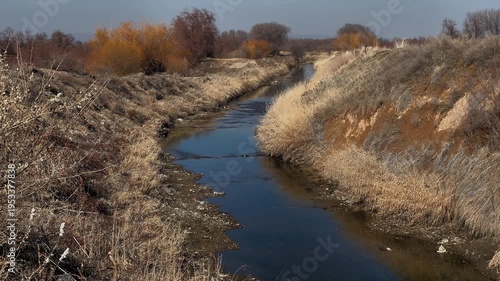 Autumn landscape, a light breeze sways the grass, a lonely river flows slowly, silent silence,