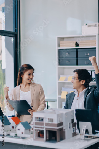 Real Estate Broker discussing with a customer model install solar roof house modern project in the office, real estate developer alternative energy, development business sustainable, zero energy, ESG.