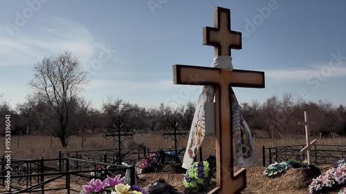 the wind sways the funeral scarf on the cross in the old rural cemetery close-up