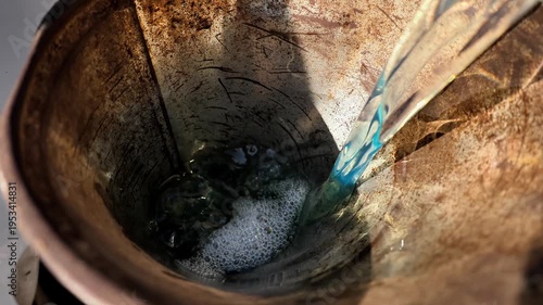 Pouring fuel into a car through the neck using a canister close-up