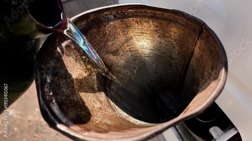 A man pours fuel into a car through the neck using a canister close-up