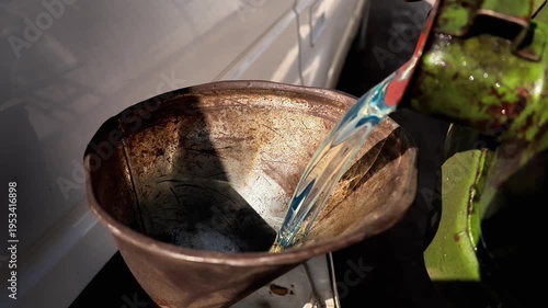 A man pours diesel fuel into a car through the neck using a canister close-up