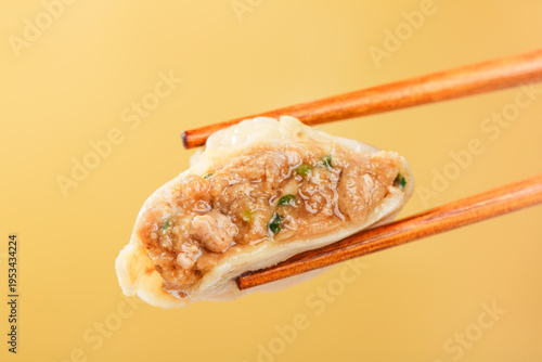 Freshly Made Pork Dumpling with Chopsticks on Yellow Background - Asian Food Photography