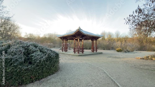 Wallpaper Mural A beautiful wooden pavilion stands in a quiet clearing surrounded by frost-covered bushes. The soft morning sky creates a feeling of peaceful isolation in the crisp winter air. Torontodigital.ca