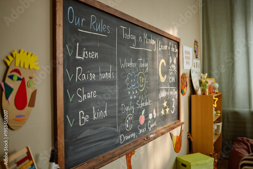 Obraz na plátně Kindergarten classroom chalkboard displaying daily schedule, weather chart, and