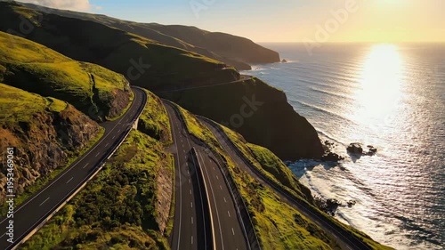 Scenic coastal highway curves along lush green hillsides, with the sun setting over the ocean, creating a breathtaking view of nature's beauty and tranquility