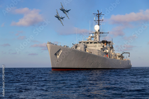 A pair of military aircraft fly over a warship during a mission in the Persian Gulf.
