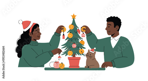 African american couple wearing santa hats decorating a christmas tree with orange slices and ornaments while their pet cat looks on happily.