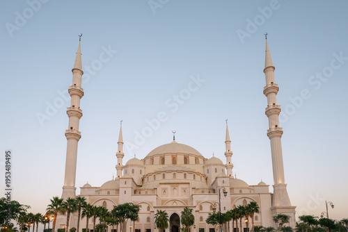 Sheikh Zayed Mosque in Fujairah, United Arab Emirates, the second largest mosque in the UAE, featuring grand white domes and tall minarets at dusk.