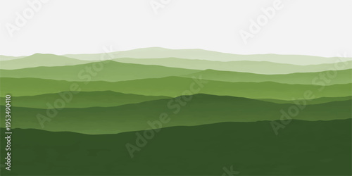Mountain landscape with clouds and fog over green hills and grass under a sunny blue sky