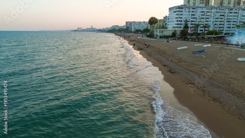 Wallpaper Mural Mersin, Turkey. Low altitude drone flight over beach surf line with foreground apartment buildings and vacationers. Mezitli coastal scene.. Aerial View Torontodigital.ca