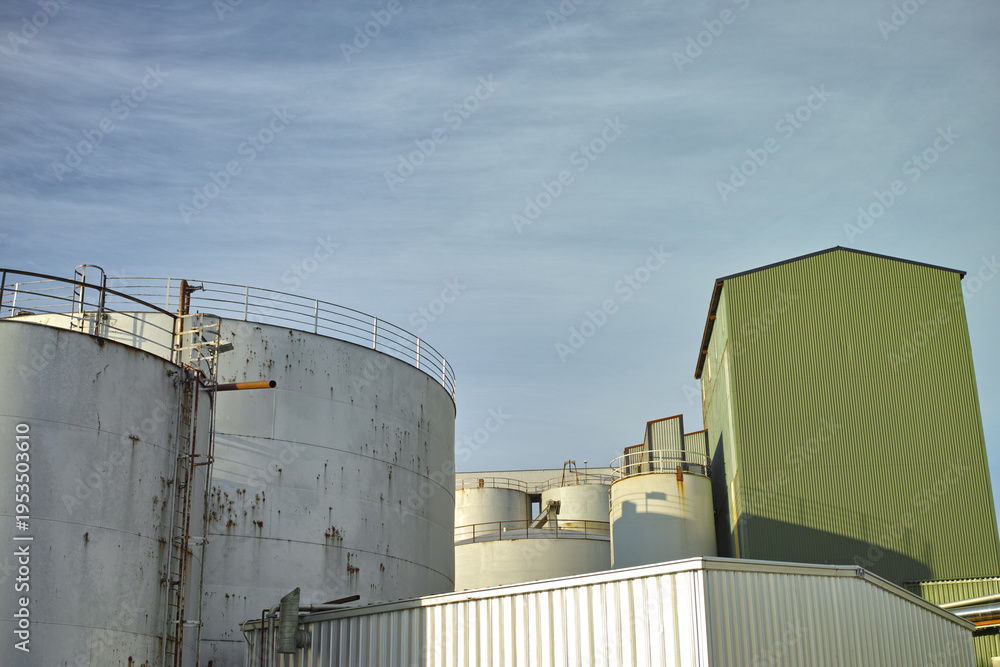 Fototapeta premium Silo, sky and architecture for agriculture, low angle and property development for business. Outdoor, empty and real estate for farming buildings, storage and industry for factory and warehouse