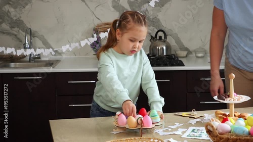 Mother and daughter are preparing for the Easter holiday together. A little girl and a Caucasian woman are sitting at a table