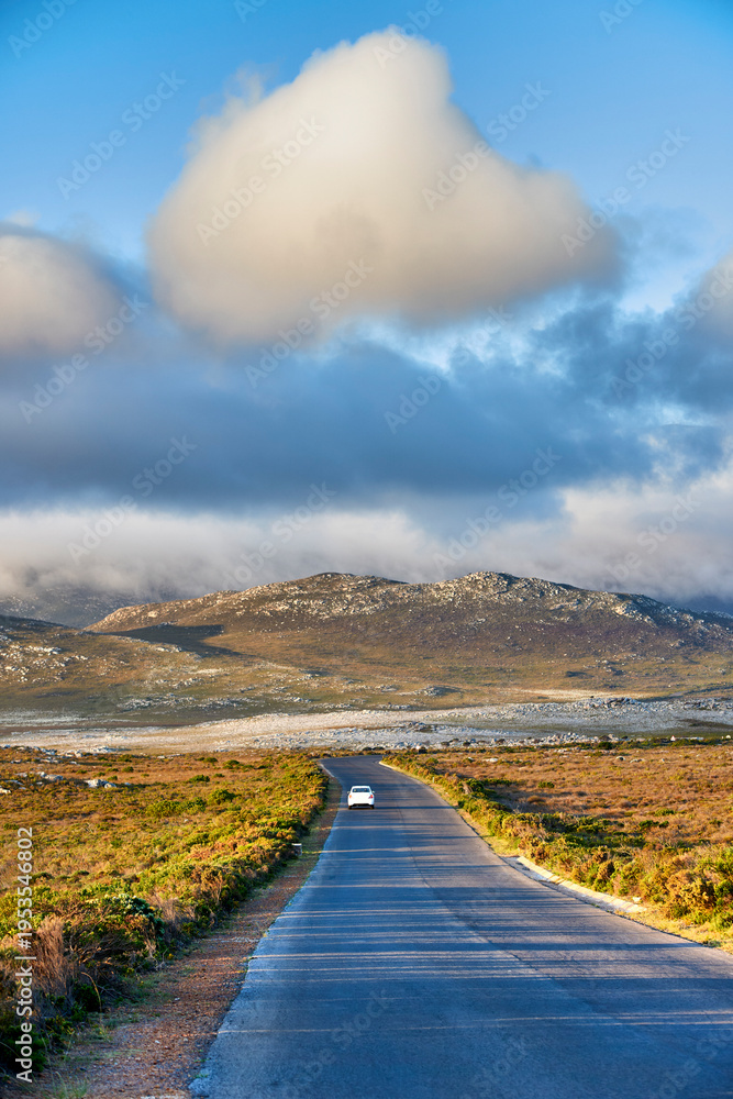 Fototapeta premium Road, nature and landscape with mountains in spring, sustainability or clouds in sky at national park. Outdoor, field and hill with car, environment and driving on horizon with flora in ecosystem