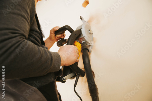 Obraz na plátně A worker using a wall chaser machine to cut grooves in a wall for electrical installations