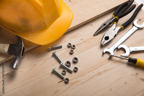 Construction Tools Hardware and Yellow Safety Helmet on Wood Workbench