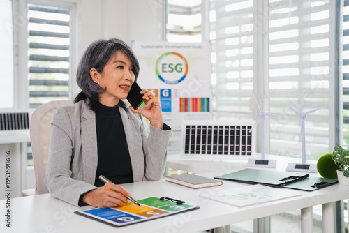 Business woman  in office Talking on phone about Sustainable Development Goals project , ESG and Business concept.