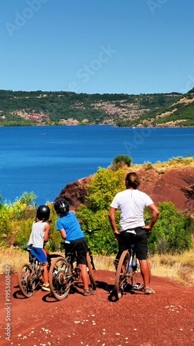 family on bike, father and children on mountain bike enjoying beautiful landscape of lake, France, Salagou