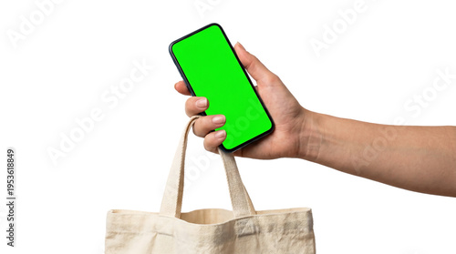 Modern customer's hand holding a smartphone with green screen and a canvas tote bag, perfect for transparent background promotions