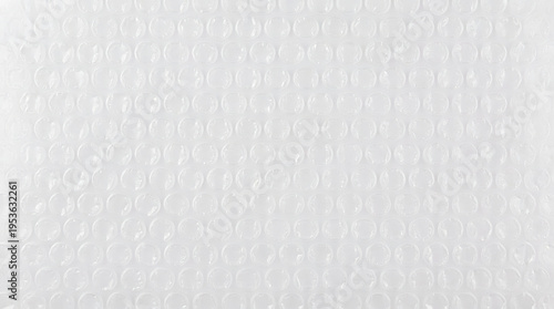 Flat texture of uniform transparent plastic bubble wrap, industrial grid packaging background.