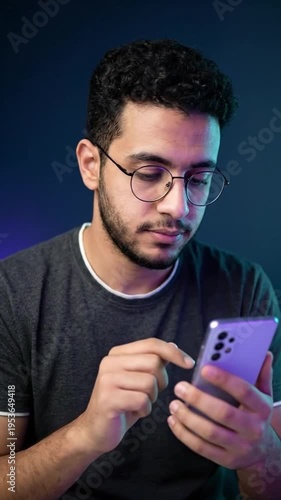 Wallpaper Mural Young man with glasses using smartphone, connected, focused on screen, modern technology Torontodigital.ca