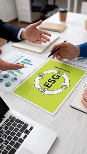 Wallpaper Mural Business meeting discussing ESG strategy, charts, laptop, and document with circular arrows. Torontodigital.ca