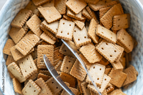 Un bol blanc rempli de petits biscuits au beurre de type petit-beurre, présenté de manière simple et gourmande dans un style minimaliste.
