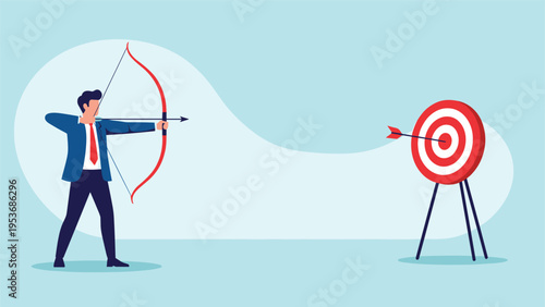 Determined businessman shooting an arrow with a red bow hitting the bullseye of a target to represent successful goal achievement.