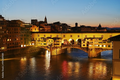 Photos The Ponte Vecchio glows warmly in the evening light, its riverside shops reflecting softly across the calm Arno