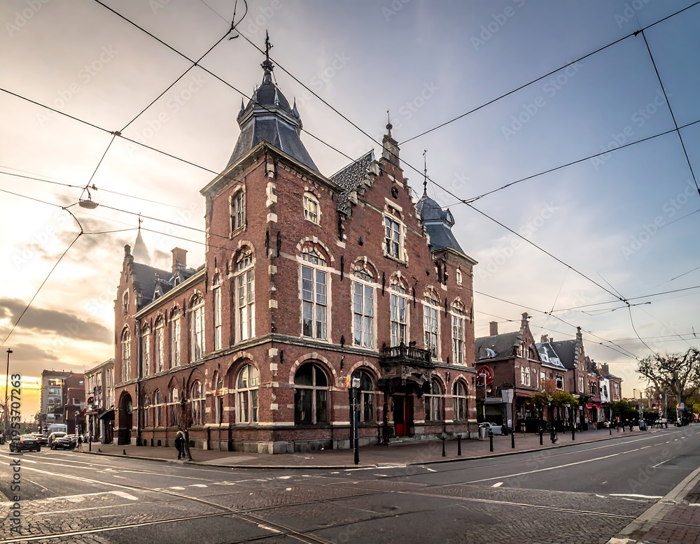 Obraz premium Ornate brick building at a street corner with sky and overhead cables