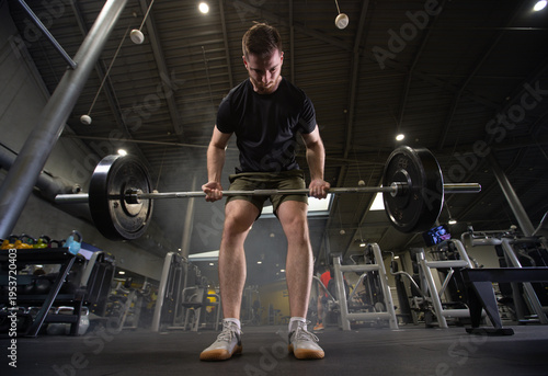 Fitness and health concept. A fit young man works out in a modern gym. Athletic man doing exercise.