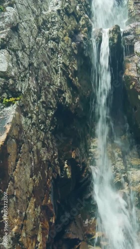 Vertical Waterfall Cascading Down Rocky Cliff